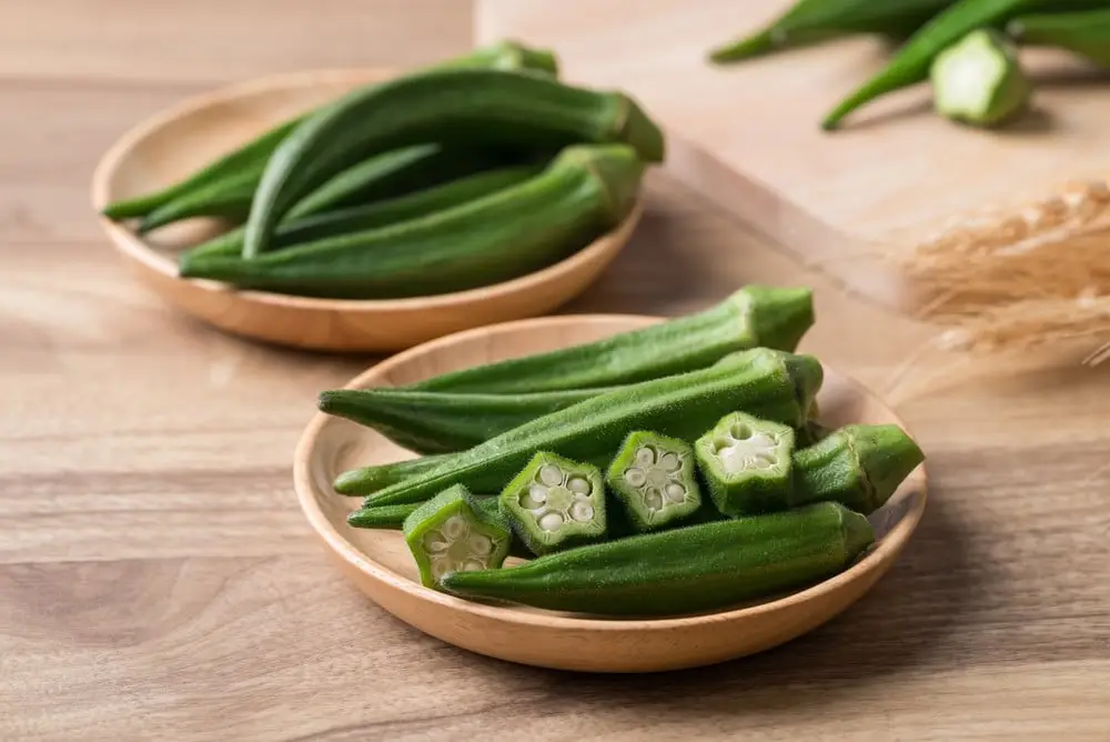 Gombos frais verts coupés sur une planche à découper en bois