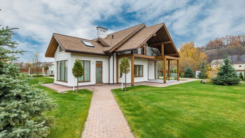 Obligation Facture Propriétaire : L'Exigence 2025 Indispensable sur la Rénovation Énergétique ! 2 Main tenant une facture détaillée devant une maison, illustrant la nouvelle obligation facture propriétaire